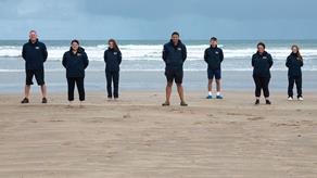 Face to face fundraisers standing side by side on a beach