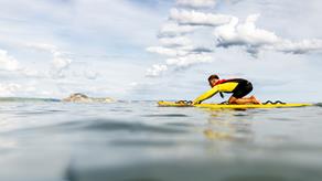 Ben Greenslade, West Dorset Lifeguard, patrolling Lyme Regis Beach using a rescue board.